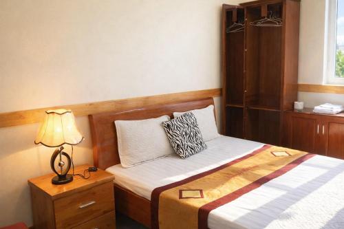 ein Schlafzimmer mit 2 Betten und einer Lampe auf einem Nachttisch in der Unterkunft Hải Long Motel Phú Thọ in Phú Thọ