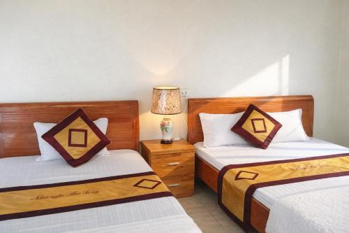 ein Schlafzimmer mit zwei Betten und einer Lampe in der Unterkunft Hải Long Motel Phú Thọ in Phú Thọ