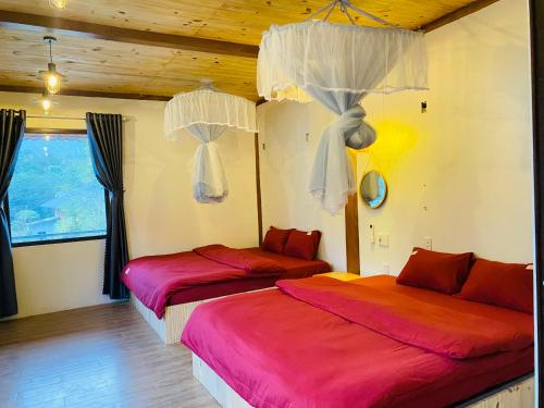 two beds in a room with wooden ceilings at Nhà Dâu Homestay in Muong Cha