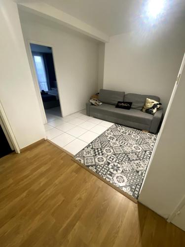 een woonkamer met een bank en een tapijt bij Le Florimorizon in Le Havre