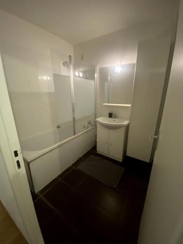 een witte badkamer met een wastafel en een douche bij Le Florimorizon in Le Havre