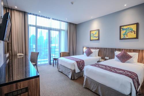 a hotel room with two beds and a television at Hotel Royal Kuala Lumpur in Kuala Lumpur