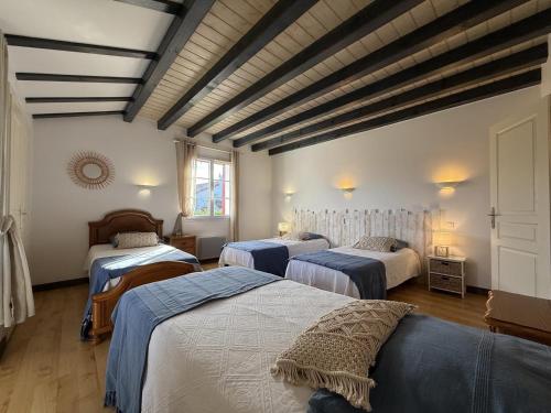 une chambre avec trois lits dans une chambre dans l'établissement Errotalde-berria bi, à Sare