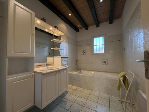 une salle de bain avec une baignoire et un lavabo et une baignoire dans l'établissement Errotalde-berria bi, à Sare