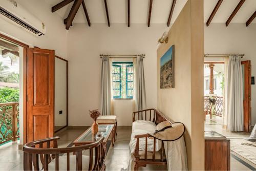 een woonkamer met een bank en een tafel bij Sanctuary by RÊVE Escapes - Premium 3 BHK Villa with Private Pool Near Morjim Beach in Siolim