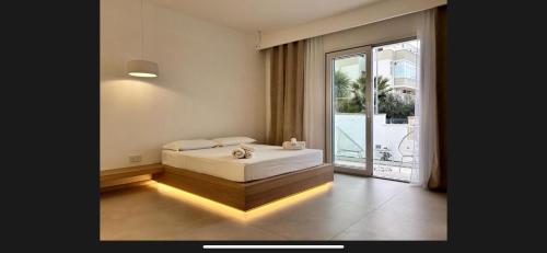 una camera da letto con un letto e una grande finestra di Relais Dolce Vita a Porto Cesareo