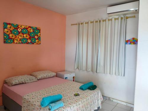 a bedroom with a bed with blue pillows on it at Aquarela Suítes in Piúma