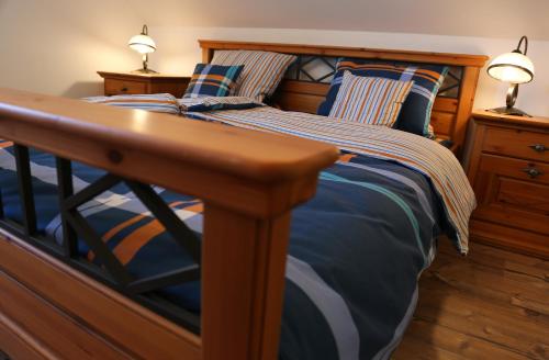 a bedroom with a bed with a wooden frame and two lamps at Penzion Recall in Troskovice