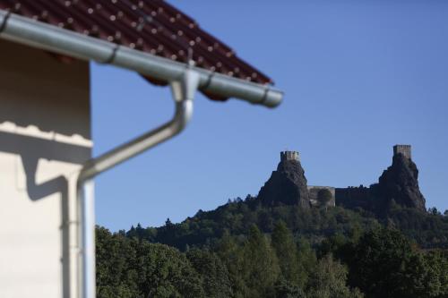 a house with a mountain in the background at Penzion Recall in Troskovice