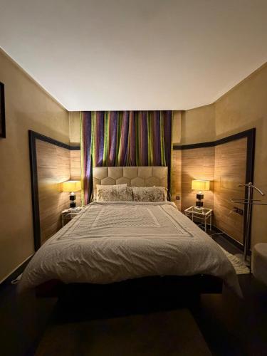 a bedroom with a large bed with two lamps at Welcome to your Stylish apartment in Oulad Akkou