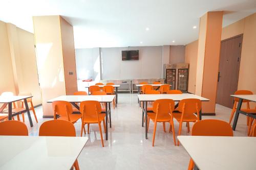 an empty classroom with tables and orange chairs at VELIN Pattaya Hotel in Pattaya Central