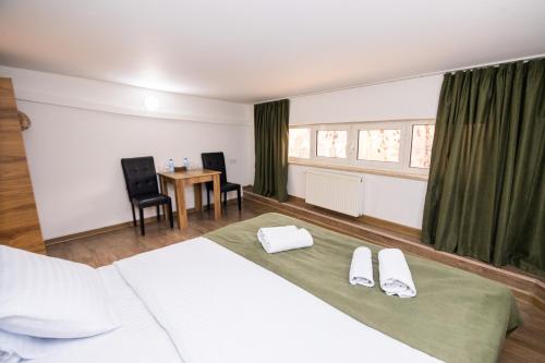 a bedroom with a bed and a table with chairs at MBM Hotel in Yerevan