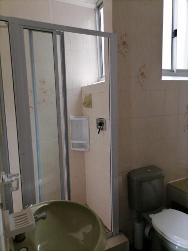 a bathroom with a green tub and a toilet at Inyoni Rocks Cabanas 42 in Amanzimtoti