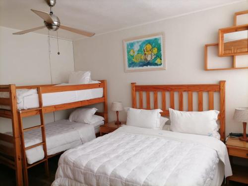 a bedroom with two beds and a bunk bed at Inyoni Rocks Cabanas 42 in Amanzimtoti