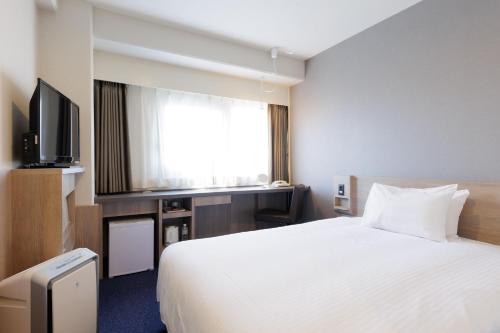 een hotelkamer met een bed en een televisie bij Osaka Garden Palace in Osaka
