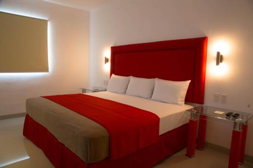 a bedroom with a large bed with a red headboard at Hotel Zar Merida in Mérida