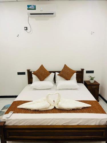a bed with two white towels on top of it at Bliss Haven Transit Hotel in Negombo