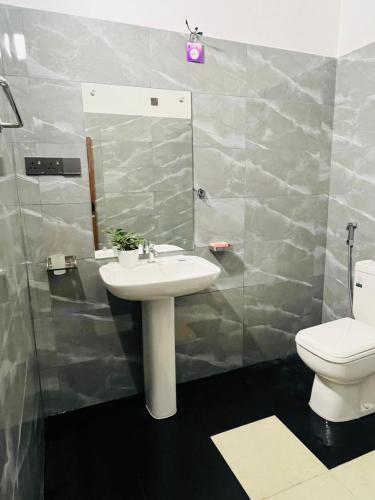 a bathroom with a sink and a toilet at Bliss Haven Transit Hotel in Negombo