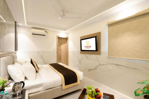 a hotel room with a bed and a flat screen tv at Hotel Era Premium Near Delhi Airport in New Delhi