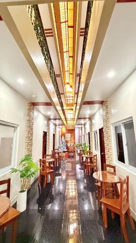 a restaurant with wooden tables and wooden chairs at SANJH Island Hotel powered by Cocotel in Roxas