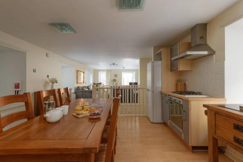 a kitchen and dining room with a wooden table and chairs at Cozy 3BR escape near Edinburgh centre in Edinburgh