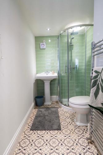 a bathroom with a sink and a shower and a toilet at Stather Cottage in Burton upon Stather