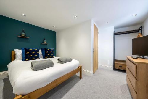 a bedroom with a large bed and a flat screen tv at Stather Cottage in Burton upon Stather