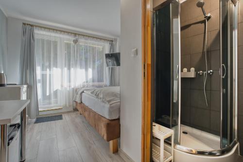 een slaapkamer met een bed en een glazen douche bij 4 Pory Roku in Karpacz