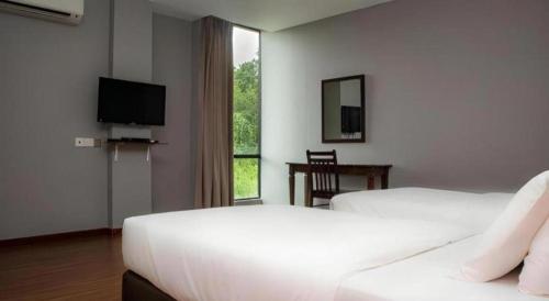 a hotel room with two beds and a flat screen tv at Hotel El Zahraa in Kampong Tongka