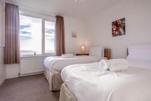two beds in a room with a window at Shore Cottage - Lower Largo in Lower Largo