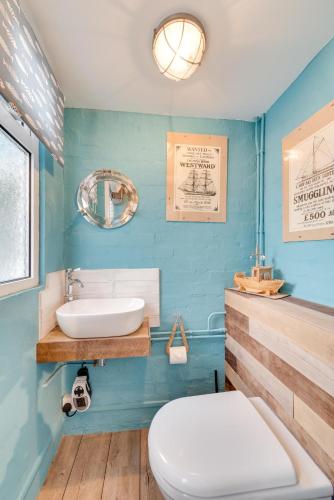 a blue bathroom with a sink and a toilet at 3 Bed in Beer oc-jb9wes in Beer