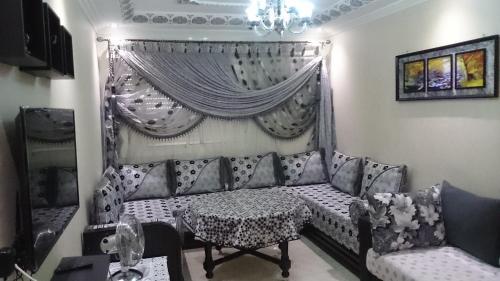 een woonkamer met een bank en een tafel bij Jawharat Tetouan in Souani