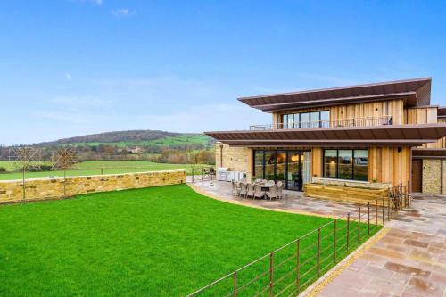 a house with a green lawn in front of it at Badgerwood in Winchcombe