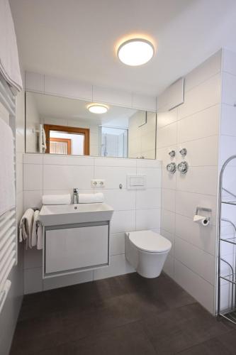 a white bathroom with a sink and a toilet at Ferienwohnung Nau in Oberstdorf