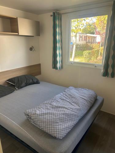 a bed in a room with a window at GRS Mobil Home in Onzain