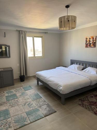 a bedroom with a large white bed and a window at Apartment in Elshatby in Alexandria