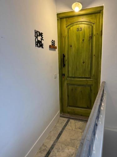 a green wooden door in a room with a bench at Apartment in Elshatby in Alexandria
