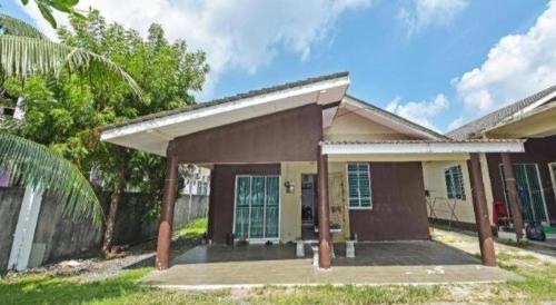 una pequeña casa con porche y valla en OYO 90596 Casaria Inn, en Kampong Baru