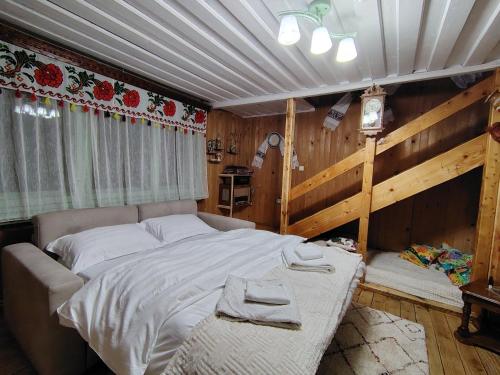 a bedroom with a large bed in a room at Casuta Mariei, Borsa,Maramures in Borşa