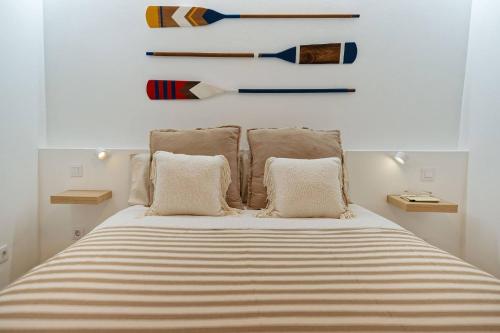 een slaapkamer met een bed met gestreepte lakens en kussens bij Royal Blue San Agustin in San Bartolomé