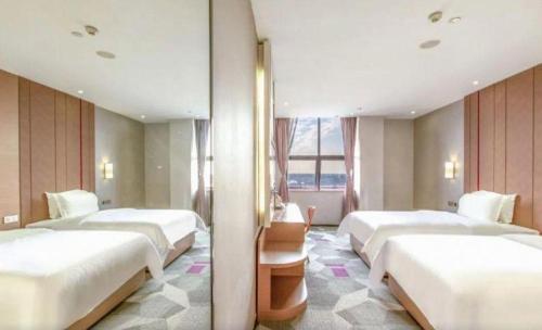 eine Reihe von Betten in einem Hotelzimmer in der Unterkunft Shenzhen Lavande Hotel Airport Terminal Branch in Baoan