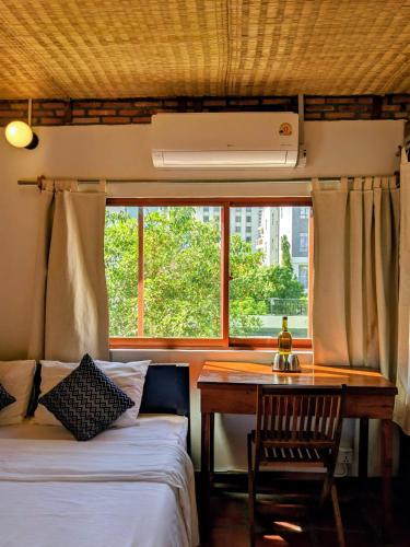 a bedroom with two beds and a desk and a window at YK Art House & Bong Bonlai Vegan in Phnom Penh