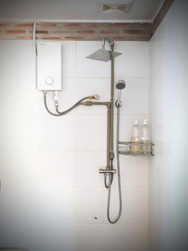 a shower in a bathroom with white tiles at YK Art House & Bong Bonlai Vegan in Phnom Penh