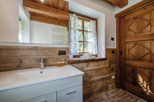 bagno con lavandino bianco e porta in legno di Chalet Maison Felix a Pra Neiron