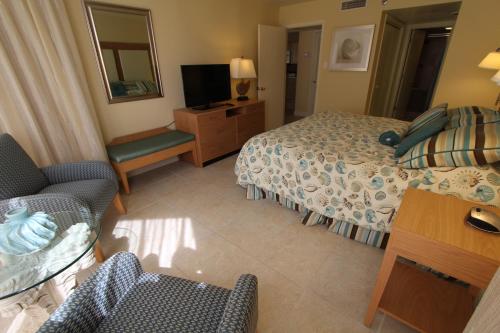 a hotel room with a bed and a television at Royale Beach and Tennis Club, a VRI resort in South Padre Island