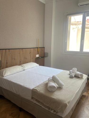 een slaapkamer met een groot bed met handdoeken erop bij B&B Valencia in Valencia