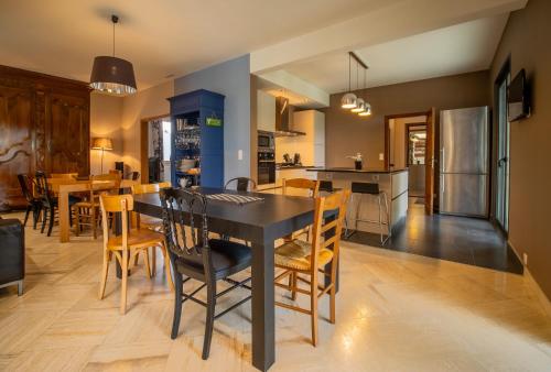 une cuisine et une salle à manger avec une table et des chaises noires dans l'établissement Les chambres de Lagarrigue, soirée étape, à Senouillac