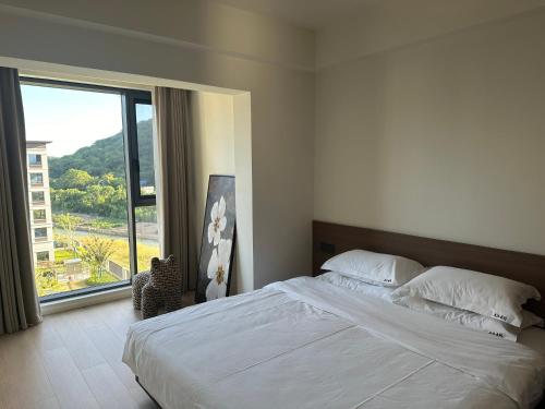 a bedroom with a large bed and a large window at Tinghaitang in Recao