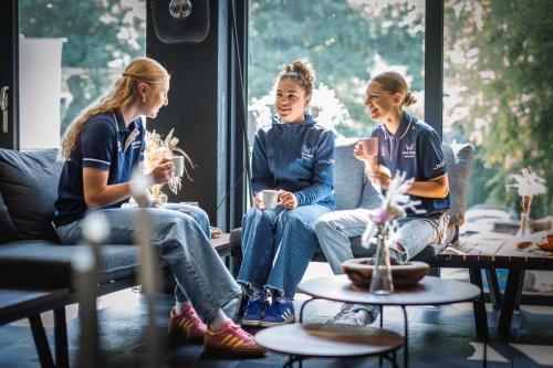 锡塔德The Tower Sportshostel的三个女孩坐在沙发上