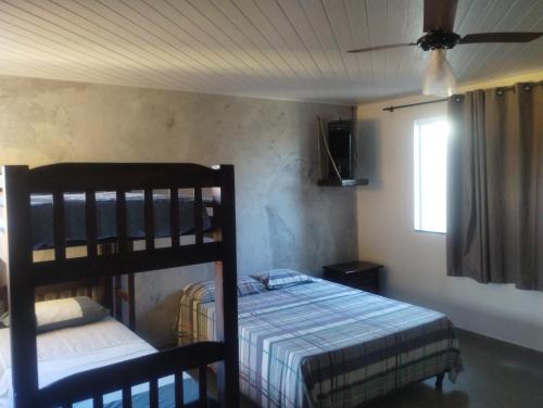 阿拉亚尔-杜卡布Casa Airport的一间卧室，有两张双层床和一扇窗户